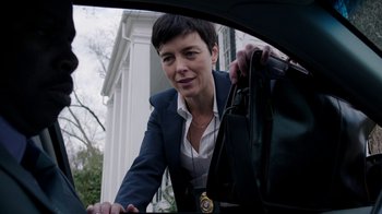 Movie still from “Sabotage” (2014), directed by David Ayer – A woman in a suit and tie holding onto a bag; Medium shot, Low angle