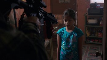Movie still from “Sabotage” (2014), directed by David Ayer – A little girl standing in front of a man holding a gun; Medium shot, Over the shoulder angle