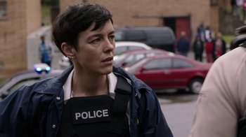 Movie still from “Sabotage” (2014), directed by David Ayer – A woman in a police uniform standing in a parking lot; Close Up shot, Over the shoulder angle