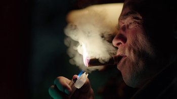 Movie still from “Sabotage” (2014), directed by David Ayer – A man is smoking a cigarette with a lit cigarette holder; Close Up shot, Low angle