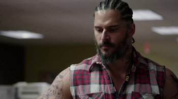 Movie still from “Sabotage” (2014), directed by David Ayer – A man with a beard and tattoos on his arms; Close Up shot, Over the shoulder angle