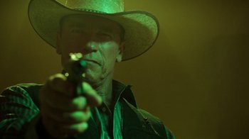 Movie still from “Sabotage” (2014), directed by David Ayer – A man in a cowboy hat is holding a gun; Close Up shot, Low angle