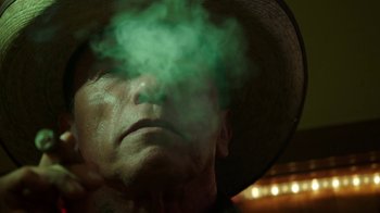 Movie still from “Sabotage” (2014), directed by David Ayer – A person wearing a hat with smoke coming out of it; Close Up shot, Low angle