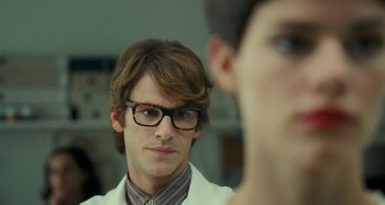 Movie still from “Saint Laurent” (2014), directed by Bertrand Bonello – A young man wearing glasses looking at himself in the mirror; Close Up shot, Over the shoulder angle