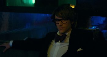 Movie still from “Saint Laurent” (2014), directed by Bertrand Bonello – A young man in a suit and bow tie; Medium shot, Low angle