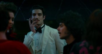 Movie still from “Saint Laurent” (2014), directed by Bertrand Bonello – A man in a white tuxedo talking on a cell phone; Close Up shot, Over the shoulder angle