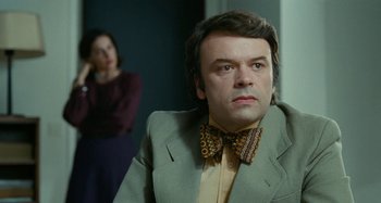 Movie still from “Saint Laurent” (2014), directed by Bertrand Bonello – A man wearing a suit and a bow tie; Close Up shot, Over the shoulder angle