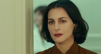 Movie still from “Saint Laurent” (2014), directed by Bertrand Bonello – A person wearing a brown shirt; Close Up shot, Over the shoulder angle