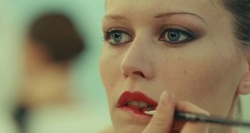 Movie still from “Saint Laurent” (2014), directed by Bertrand Bonello – A person putting makeup on her face; Extreme Close Up shot, Over the shoulder angle