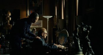 Movie still from “Saint Laurent” (2014), directed by Bertrand Bonello – A man and a woman sitting in front of a computer; Medium shot, Over the shoulder angle