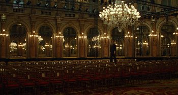 A man walking through a room with many chairs