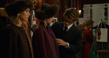 Movie still from “Saint Laurent” (2014), directed by Bertrand Bonello – A man helping a woman put on a jacket; Medium shot, Over the shoulder angle
