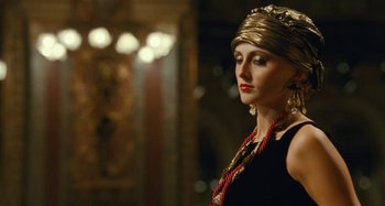 Movie still from “Saint Laurent” (2014), directed by Bertrand Bonello – A woman in a gold headpiece and a black dress; Close Up shot, Low angle