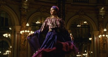 Movie still from “Saint Laurent” (2014), directed by Bertrand Bonello – A woman in a purple dress and purple head scarf; Wide shot, Low angle