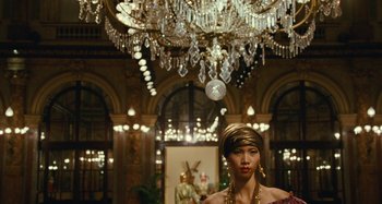 Movie still from “Saint Laurent” (2014), directed by Bertrand Bonello – A woman wearing a gold headpiece and a gold necklace; Medium shot, Low angle