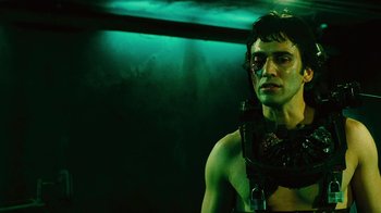 Movie still from “Saw II” (2005), directed by Darren Lynn Bousman – A man in a green outfit with a gun in his hand; Close Up shot, Low angle