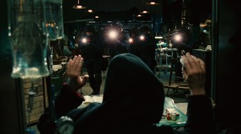 Movie still from “Saw II” (2005), directed by Darren Lynn Bousman – A group of people sitting at a table in a room; Medium shot, Over the shoulder angle