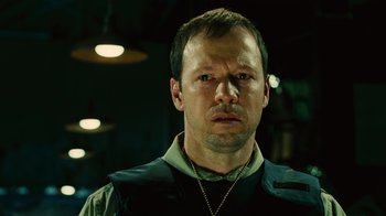 Movie still from “Saw II” (2005), directed by Darren Lynn Bousman – A person wearing a vest; Close Up shot, High angle