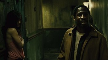 Movie still from “Saw II” (2005), directed by Darren Lynn Bousman – A man standing in a room with a wall behind him; Medium shot, Over the shoulder angle