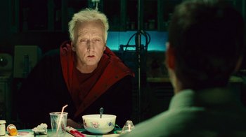 Movie still from “Saw II” (2005), directed by Darren Lynn Bousman – An older man sitting at a table with a bowl of soup; Close Up shot, Over the shoulder angle