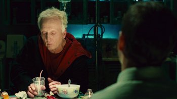 Movie still from “Saw II” (2005), directed by Darren Lynn Bousman – An older man sitting at a table with a bowl of soup; Medium shot, High angle
