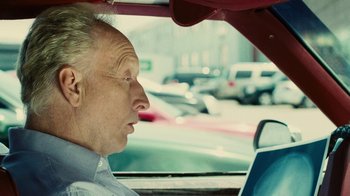 Movie still from “Saw II” (2005), directed by Darren Lynn Bousman – An older man driving a car in the street; Close Up shot, Over the shoulder angle