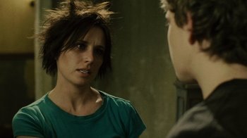 Movie still from “Saw II” (2005), directed by Darren Lynn Bousman – A woman with a messy hair style talking to a man in front of a wall; Close Up shot, Over the shoulder angle