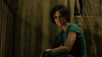 Movie still from “Saw II” (2005), directed by Darren Lynn Bousman – A woman sitting on a chair in front of a wall; Close Up shot, Over the shoulder angle