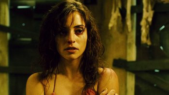 Movie still from “Saw II” (2005), directed by Darren Lynn Bousman – A young woman with red eye makeup looking at the camera; Close Up shot, Low angle