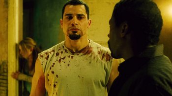 Movie still from “Saw II” (2005), directed by Darren Lynn Bousman – A man in a white shirt is looking at another man; Close Up shot, Over the shoulder angle