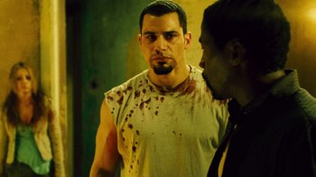 Movie still from “Saw II” (2005), directed by Darren Lynn Bousman – A man in a white shirt is looking at a man in a black tie; Close Up shot, Over the shoulder angle