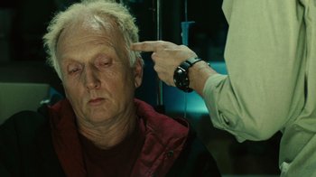 Movie still from “Saw II” (2005), directed by Darren Lynn Bousman – An older man is being examined by a doctor; Close Up shot, High angle