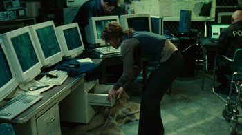 Movie still from “Saw II” (2005), directed by Darren Lynn Bousman – A woman and a man working in a computer room; Medium shot, High angle