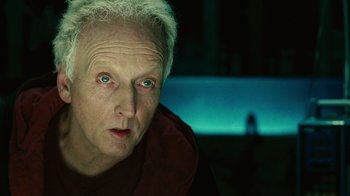 Movie still from “Saw II” (2005), directed by Darren Lynn Bousman – An older man with white hair and blue eyes looking at the camera; Close Up shot, Low angle