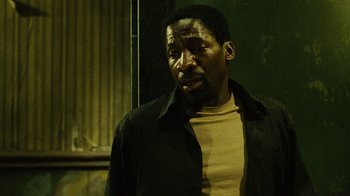 Movie still from “Saw II” (2005), directed by Darren Lynn Bousman – A man in a black shirt and a yellow shirt; Close Up shot, Low angle