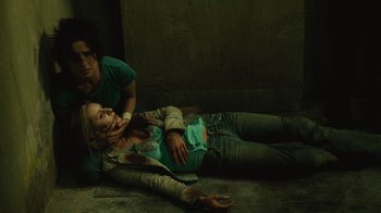 Movie still from “Saw II” (2005), directed by Darren Lynn Bousman – Two people laying on the ground in a dark room; Medium shot, Overhead angle