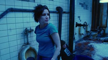 Movie still from “Saw II” (2005), directed by Darren Lynn Bousman – A woman standing next to a urinal in a bathroom; Medium shot, Low angle
