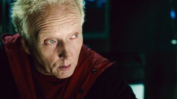 Movie still from “Saw II” (2005), directed by Darren Lynn Bousman – An older man with white hair and blue eyes looking at the camera; Close Up shot, Over the shoulder angle