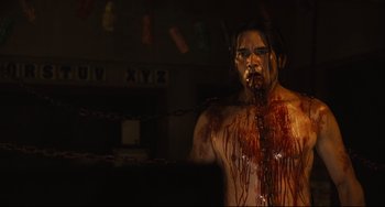 Movie still from “Saw III” (2006), directed by Darren Lynn Bousman – A man with blood all over his face and chest; Medium shot, Over the shoulder angle