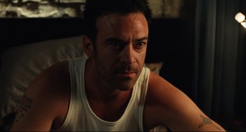 Movie still from “Saw III” (2006), directed by Darren Lynn Bousman – A person sitting on a bed wearing a tank top; Close Up shot, Over the shoulder angle