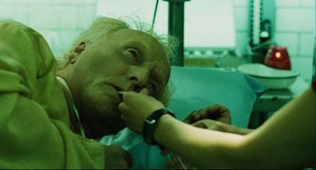 Movie still from “Saw III” (2006), directed by Darren Lynn Bousman – A woman is putting a tooth brush in her mouth while sitting in a dentist chair; Close Up shot, High angle