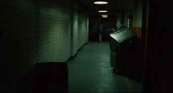Movie still from “Saw III” (2006), directed by Darren Lynn Bousman – A man is walking through a hallway with a trash can; Wide shot, High angle