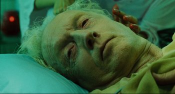 Movie still from “Saw III” (2006), directed by Darren Lynn Bousman – An old man laying in a bed with green hair; Close Up shot, Overhead angle