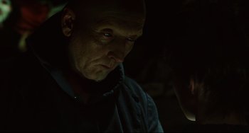 Movie still from “Saw III” (2006), directed by Darren Lynn Bousman – A man with a bald head looking at the camera; Close Up shot, Over the shoulder angle
