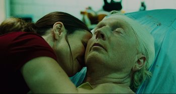 Movie still from “Saw III” (2006), directed by Darren Lynn Bousman – A man and a woman laying on top of each other; Close Up shot, Low angle
