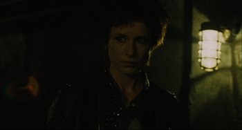Movie still from “Saw III” (2006), directed by Darren Lynn Bousman – A woman in a leather jacket is in the dark; Close Up shot, Over the shoulder angle