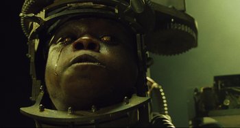 Movie still from “Saw III” (2006), directed by Darren Lynn Bousman – A man's face in a metal helmet; Extreme Close Up shot, Overhead angle