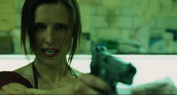 Movie still from “Saw III” (2006), directed by Darren Lynn Bousman – A woman is holding a gun in her hand; Close Up shot, Low angle