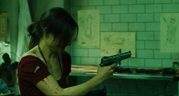 Movie still from “Saw III” (2006), directed by Darren Lynn Bousman – A woman holding a gun in a room with green walls; Close Up shot, High angle