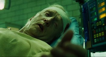 Movie still from “Saw III” (2006), directed by Darren Lynn Bousman – An older man laying in a bed with a bandage on his head; Close Up shot, High angle